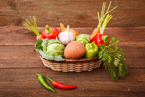 Fresh vegetables in a basket on a wooden background. Cabbage, be - Fotoğraf, Görsel