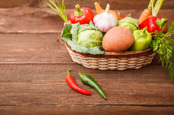 Fresh vegetables in a basket on a wooden background. Cabbage, be - Foto, Imagem