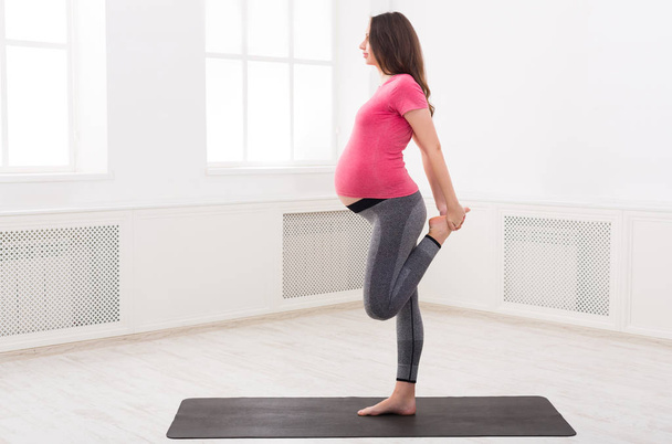 Mulher grávida alongamento pernas formação dentro de casa
 - Foto, Imagem