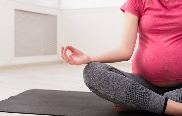 Felismerhetetlen terhes nő meditál otthon - Fotó, kép