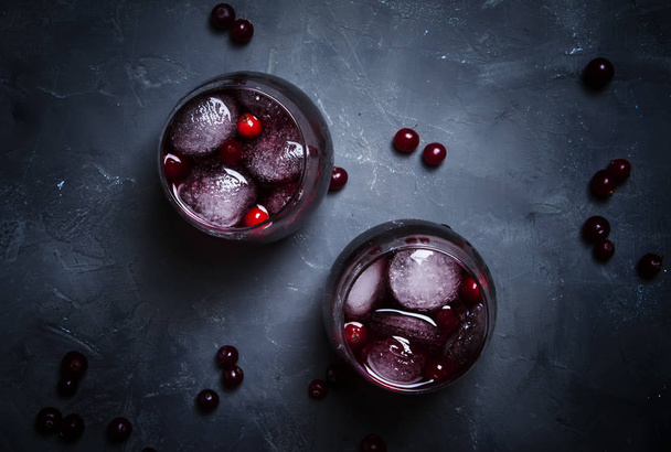 Alcohol cocktail with cranberries and ice, gray stone background, top view - Foto, Imagem