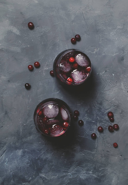 Alcohol cocktail with cranberries and ice, gray stone background, top view - Foto, Imagem