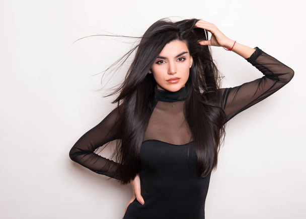 beautiful young woman with long black hair wearing dress and posing on white background - 写真・画像