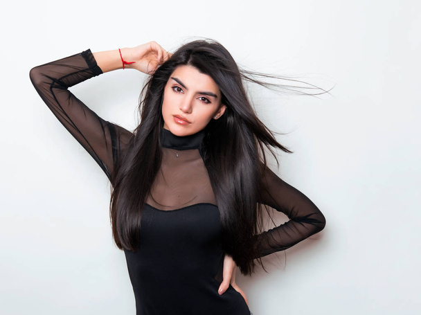 beautiful young woman with long black hair wearing dress and posing on white background - Fotoğraf, Görsel