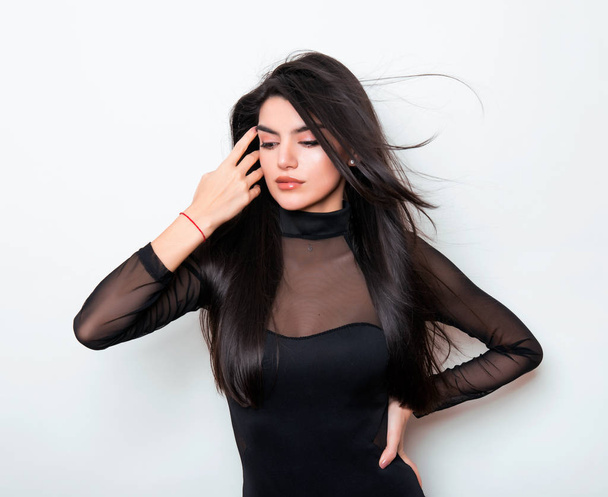 beautiful young woman with long black hair wearing dress and posing on white background - Foto, afbeelding