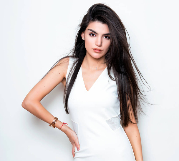 beautiful young woman with long black hair wearing dress and posing on white background - Valokuva, kuva