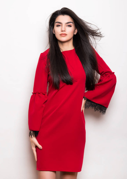 beautiful young woman with long black hair wearing dress and posing on white background - Fotó, kép