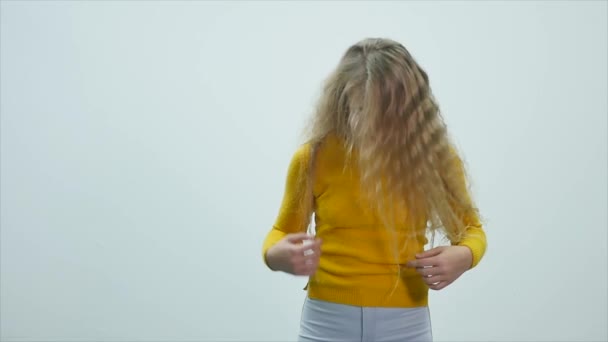 young teenage girl is shaking her head, playing with hair and looking at the camera - Filmmaterial, Video