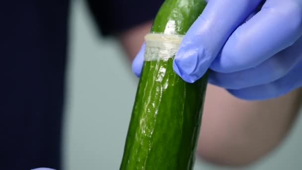 Male hands holding cucumber with condom. Safe sex concept - Materiał filmowy, wideo