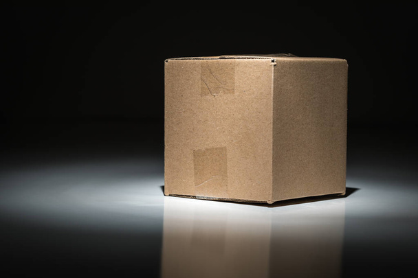 Blank Carboard Shipping Box Under Spot Light. - Photo, Image