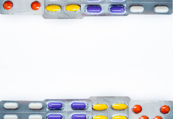 Tabletten pillen geneeskunde in blisterverpakking met frame patroon en ruimte box voor tekst. Kleurrijke tabletten pillen met creatieve patroon op witte achtergrond. Achtergrond voor gezondheidszorg onderwijs. - Foto, afbeelding