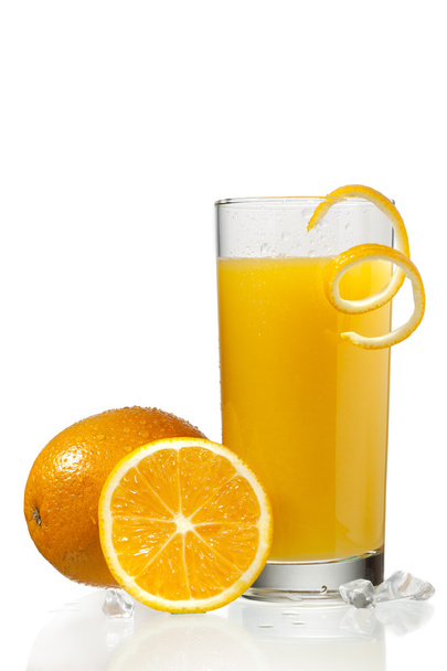 Vaso de jugo de naranja con pelado de naranja al lado de las naranjas
 - Foto, Imagen