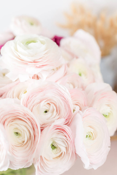 Персидский лютик. Бледно-розовые цветки раннункулуса на светлом фоне. Стеклянная ваза на розовом винтажном деревянном столе. Обои
 - Фото, изображение