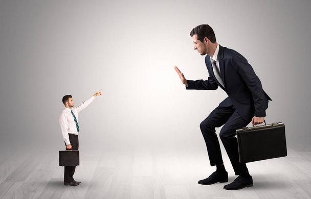 Small businessman pointing to a giant businessman - Foto, Imagen