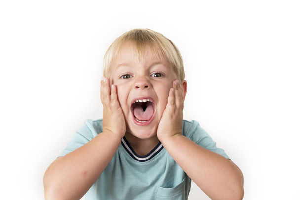 Porträt eines 3-jährigen kleinen blonden Kindes mit offenem Mund, das überrascht oder verängstigt schreit und seinen Kopf mit seinen kleinen Händen isoliert auf weiß hält - Foto, Bild