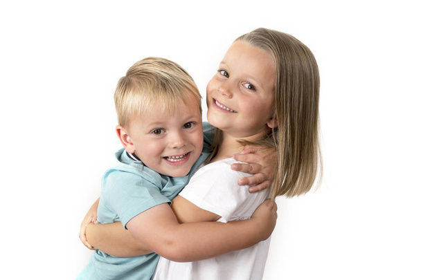 7 Jahre alte entzückende blonde fröhliche Mädchen posiert mit ihrem kleinen Bruder 3 Jahre alt lächeln fröhlich isoliert auf weißem Hintergrund - Foto, Bild