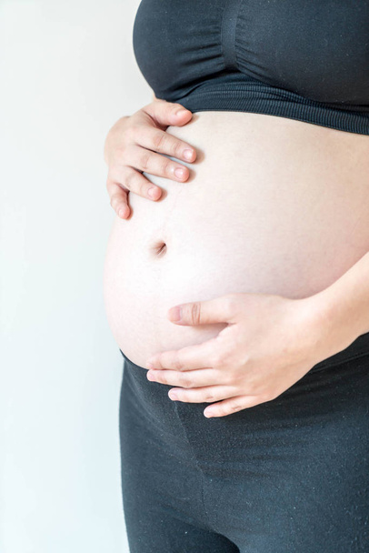 Bauch einer schwangeren Frau mit Händen - Foto, Bild