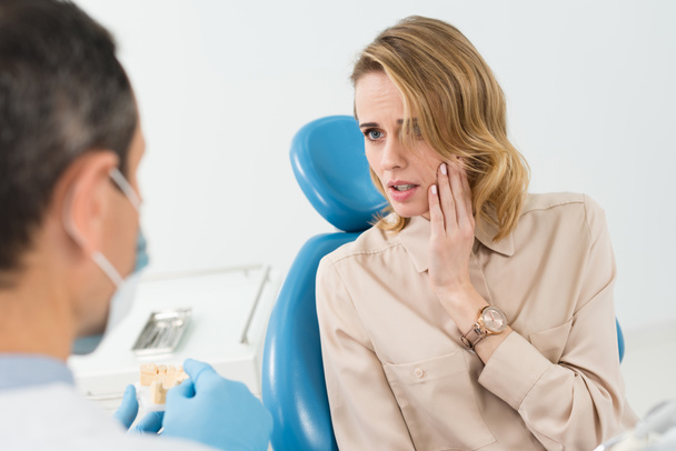 Пацієнтка, яка страждає від зубного болю в сучасній стоматологічній клініці
 - Фото, зображення