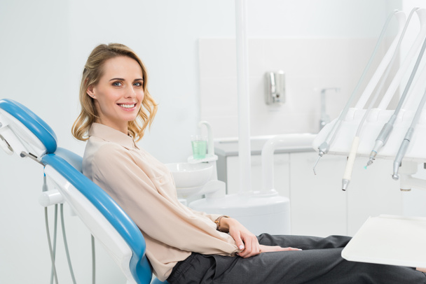 Femme souriante au check-up dans une clinique dentaire moderne
 - Photo, image