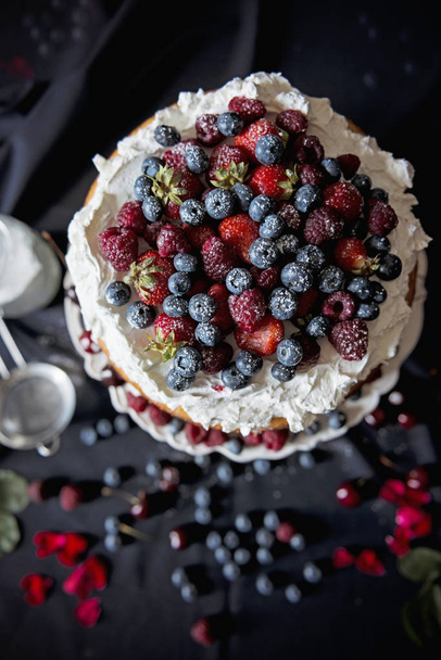 Beautiful, fruit naked cake with cooking ingredients on a dark tablecloth - Фото, зображення