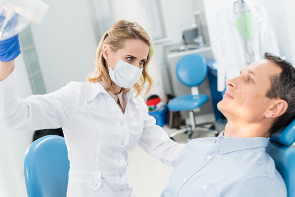 Orvos ellenőrzi a beteg fogakat a modern fogászati klinika - Fotó, kép