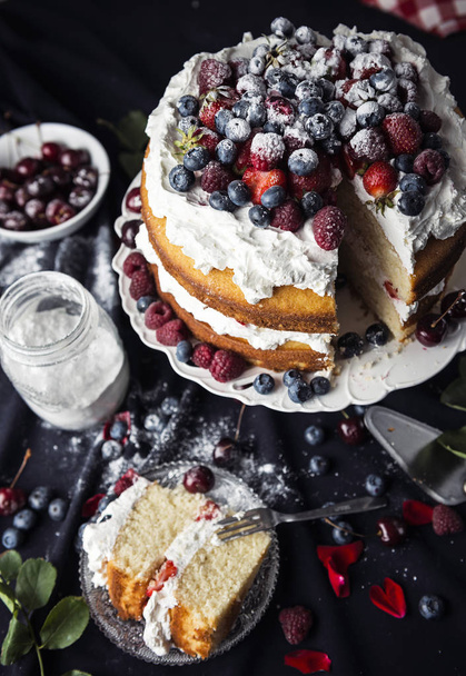 Beautiful, fruit naked cake with cooking ingredients on a dark tablecloth - 写真・画像