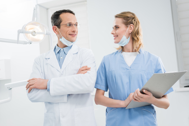 Sorrindo médicos confiantes olhando uns para os outros na clínica odontológica moderna
 - Foto, Imagem