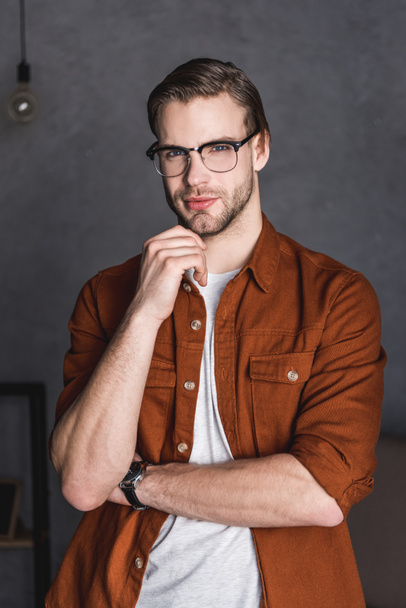 close-up portrait of thoughtful young man in eyeglasses looking at camera - Foto, imagen