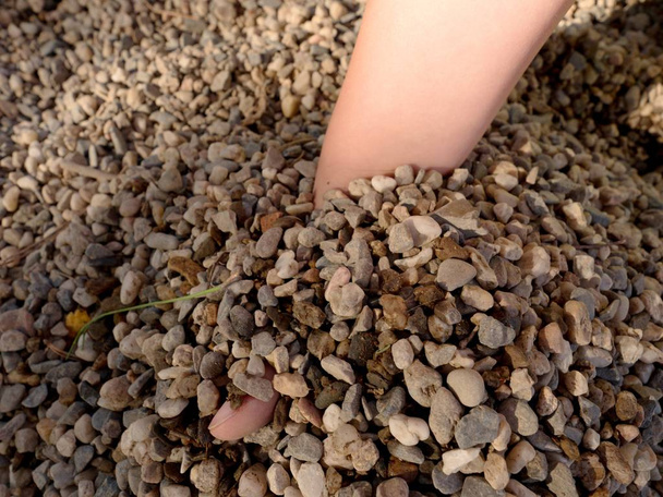 Дитяча рука будує твердиню в піску або невеликих кам'яних стовпах, зламаних гілочках і листках
 - Фото, зображення