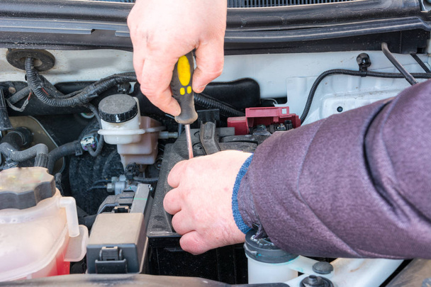 Ingénieur moteur remplace la batterie de voiture parce que la batterie de voiture est épuisée. concept car entretien en hiver
. - Photo, image