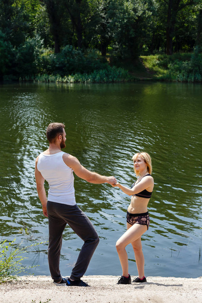 jeune homme et jeune femme marchant dans le parc près de la rivière
. - Photo, image