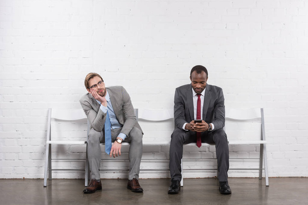 hommes d'affaires multiethniques en costumes en attente d'un entretien d'embauche
 - Photo, image