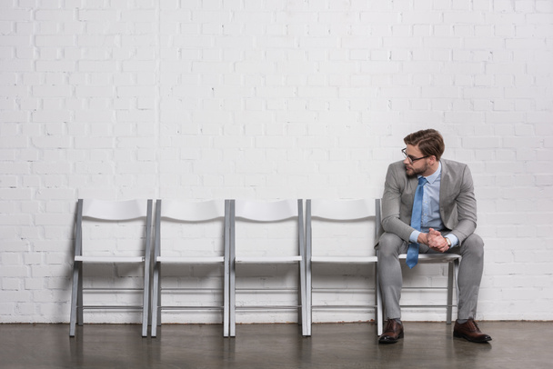 Kavkazská podnikatel při pohledu na prázdné židle při čekání na pracovní pohovor - Fotografie, Obrázek