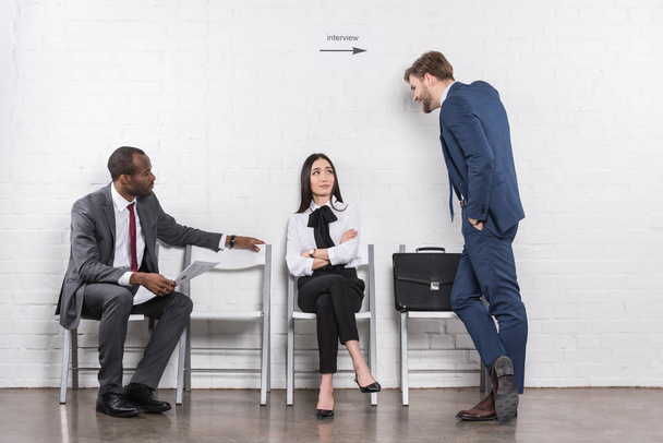 Multiethnische Geschäftsleute unterhalten sich, während sie auf ein Vorstellungsgespräch warten - Foto, Bild