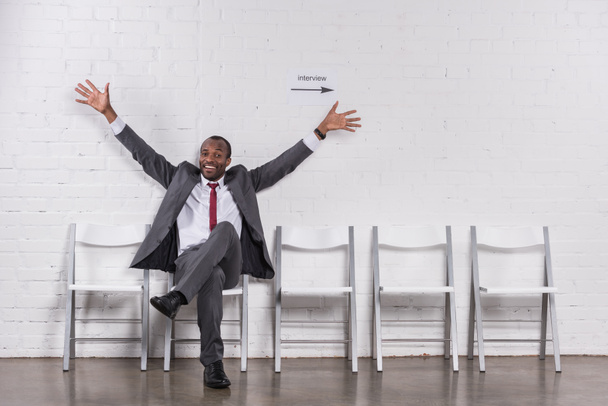 usmívající se americký podnikatel s otevřenou náručí čeká na pracovní pohovor - Fotografie, Obrázek