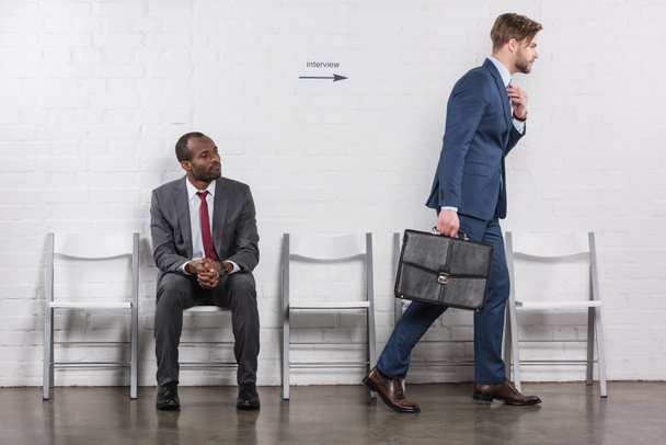 empresário afro-americano olhando para colega caucasiano indo em entrevista de emprego
 - Foto, Imagem