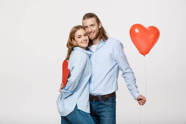 Portrait of young man and woman holding a heart- shaped balloon and paper - Photo, Image