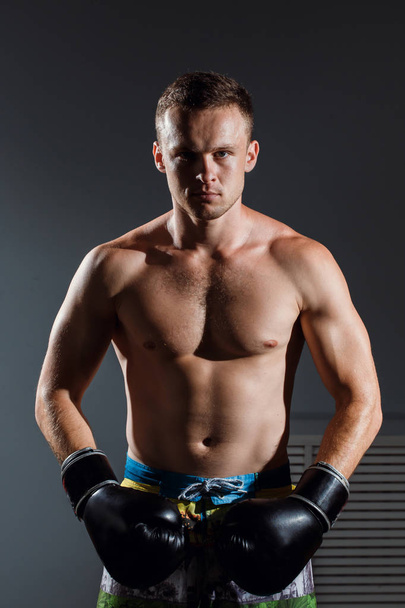 Portret van bokser in bokshandschoenen op grijze achtergrond - Foto, afbeelding