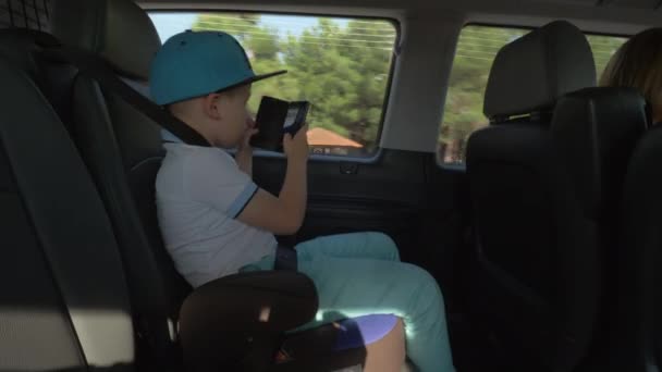 Мальчик фотографирует с сотовым во время поездки на машине
 - Кадры, видео