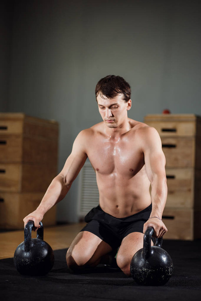 Fitness-Kettlebells schwingen Übung Mann Workout im Fitnessstudio - Foto, Bild