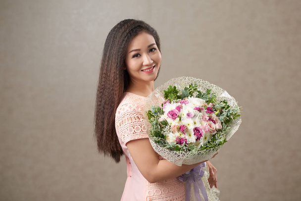 Beautiful Vietnamese birthday girl with bouquet of flowers - Valokuva, kuva