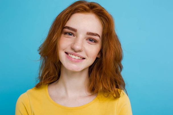 Headshot Πορτρέτο του χαρούμενος κόκκινο κορίτσι μαλλιά τζίντζερ με φακίδες χαμογελώντας κοιτάζοντας κάμερα. Μπλε φόντο παστέλ. Αντιγραφή χώρου - Φωτογραφία, εικόνα
