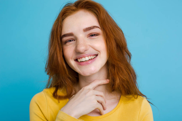 Headshot Retrato de menina de cabelo vermelho gengibre feliz com sardas sorrindo olhando para a câmera. Fundo azul pastel. Espaço de cópia - Foto, Imagem