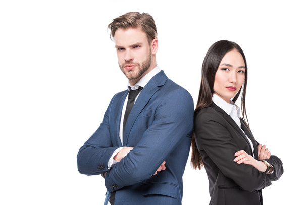 side view of multicultural business colleagues with arms crossed standing back to back isolated on white - Фото, зображення