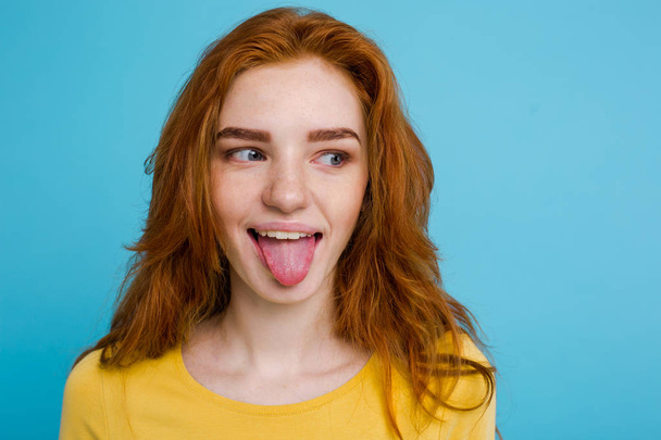 Headshot Портрет счастливой рыжеволосой девушки со смешным лицом, смотрящей в камеру. Пастельно-синий фон. Копировальное пространство
 - Фото, изображение