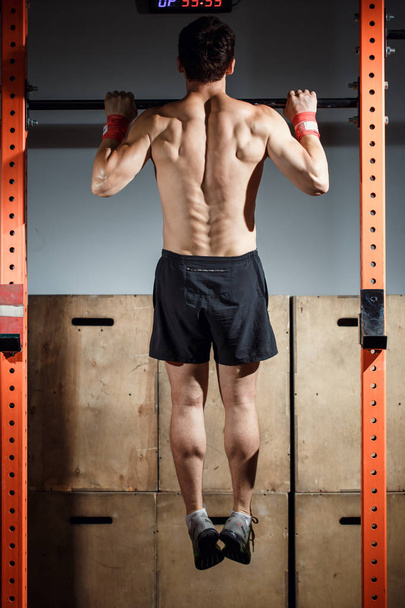 Fitness toes to bar man pull-ups bars workout exercise at gym - Foto, Imagem