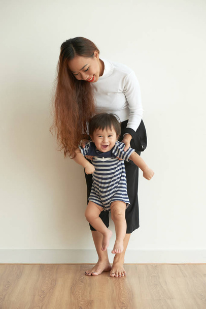 彼女の子供と遊ぶ陽気なアジアの若い女性 - 写真・画像