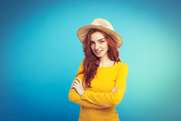 Travel concept - close-up portret jonge mooie aantrekkelijke redhair meisje met trendy hoed en zonnebril glimlachen. Blauwe Pastel achtergrond. Kopiëren van ruimte - Foto, afbeelding
