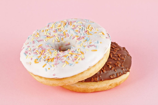 Two glazed donuts on pink background - Foto, Imagem