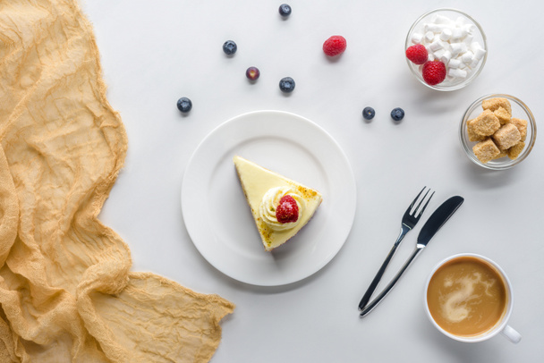 vue de dessus du morceau de gâteau avec des baies et du café sur la table blanche
 - Photo, image